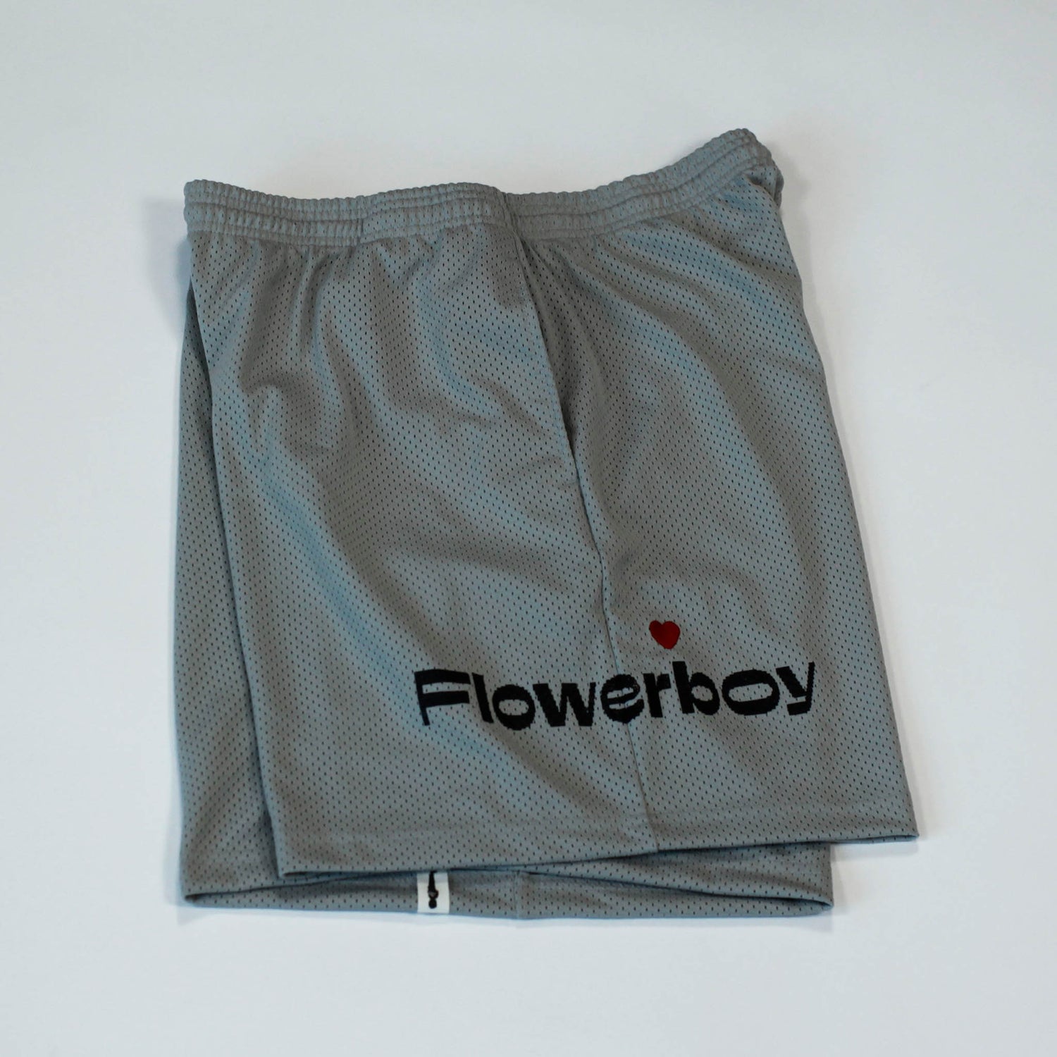 Side view of our Flowerboy black basketball shorts with printed Flowerboy Logo with red heart and a Flowerboy Tag.